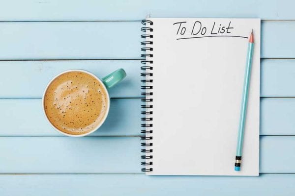 productivity-to-do-lists-jlp-coach A cup of coffee on a table next to a notebook with a to-do list